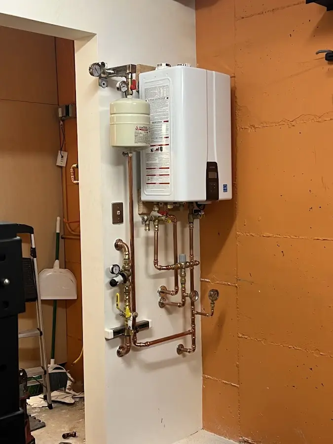 Plumbing technician inspecting water heater connections in Frederick